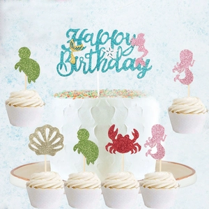 Close-up of glittery mermaid cake toppers featuring sea animals and Happy Birthday sign