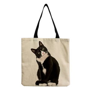 Detailed close-up of a black cat print on a natural linen tote bag with fabric texture