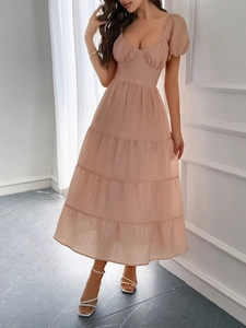 Vista intera di un abito midi rosa con maniche a sbuffo su una modella in interni