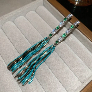 Detail of silver long tassel earrings with zircon heart and colorful bead chains