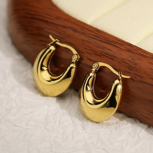 Polished gold U-shaped hollow hoop earrings displayed on a premium jewelry stand
