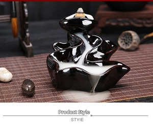 Macro view of smoke flowing down a wave-shaped black ceramic backflow incense burner