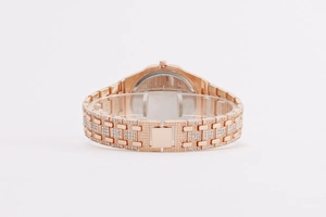 Close-up of rose gold watch band with full diamond inlay and butterfly clasp detail