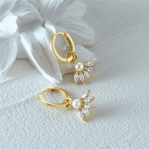 Macro detail of gold sterling silver hoop earrings with marquise stones and center pearl
