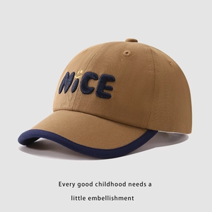 Dettaglio del ricamo NICE e faccina gialla su cappello da baseball kaki e blu