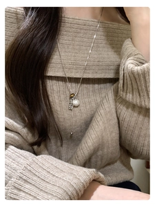 Tiger eye and pearl pendant necklace on beige sweater showing long Y-shaped chain