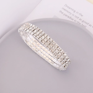 Close-up of a silver elastic bracelet featuring three rows of sparkling clear rhinestones