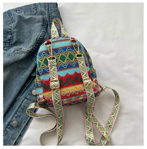 Detail of colorful woven mini backpack with patterned straps and gold hardware
