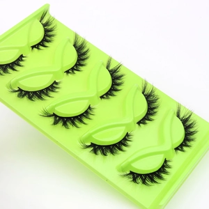 Detail of 5 pairs of dense cat-eye false eyelashes in a bright green storage tray
