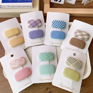 Close-up of colorful fabric hair clips set featuring plaid and wavy patterns for girls
