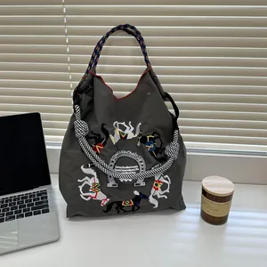 Detailed close-up of intricate horse embroidery on gray nylon Ball Chain tote bag