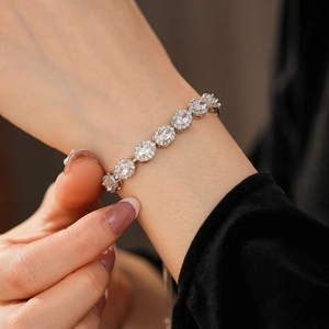 Gros plan du bracelet tennis vintage en argent avec oxydes de zirconium ovales et halo