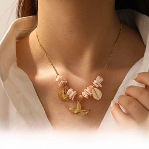Close-up of starfish and seashell pendant necklace on model with pink natural stone