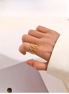 Detailed view of 18k gold plated stainless steel multi-layer oval crossover ring on finger