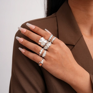Detailed view of silver minimalist ring set with irregular textures on a model