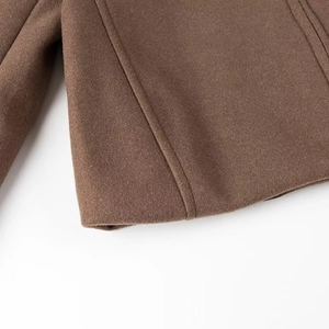 Détail de l'ourlet et de la texture épaisse en laine de la veste marron pour femme