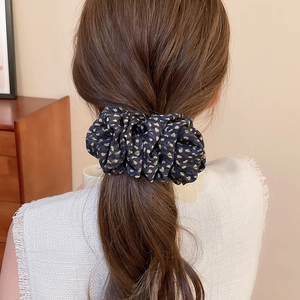 Gros plan d'un chouchou élégant avec imprimé léopard porté sur une coiffure