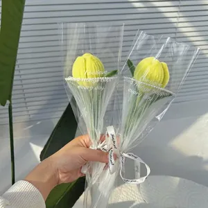 Detail of handmade yellow chenille pipe cleaner tulip bouquet in transparent gift packaging