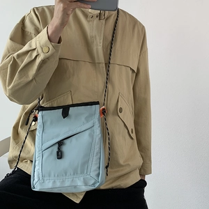 Mirror selfie showing the scale of the light blue nylon crossbody bag on a person