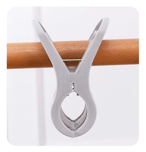 Close-up of a large grey plastic quilt clip showing windproof double-grip on a clothes rail