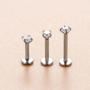 Vista macro di tre piercing labret in acciaio con pietre di zircone tondo in varie lunghezze