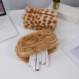 Macro view of plush pencil cases showing fluffy giraffe print and brown faux fur textures