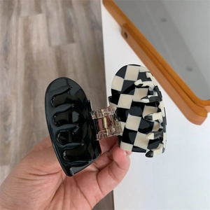 Detail of checkered heart claw clip with black inner finish and durable metal spring