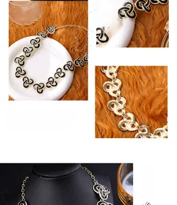 Macro view of vintage gold-plated necklace featuring black enamel triskelion charms