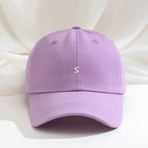 Close-up of letter S white embroidery on a light purple cotton baseball cap fabric