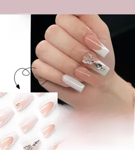 Close-up of French press-on nails featuring silver butterfly charms and sparkling rhinestones
