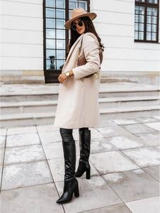 Chic beige wool coat styled with a brown saddle bag and black over-the-knee boots