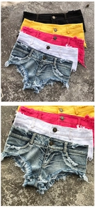 Dettaglio in piano di pantaloncini di jeans con frange e strappi in vari colori vivaci