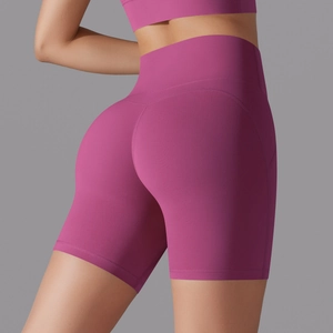 Detail view of high-waist magenta yoga shorts on model showing seamless fit and texture