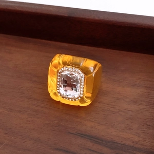 Macro detail of vintage resin hexagon ring with amber tone and large crystal inlay