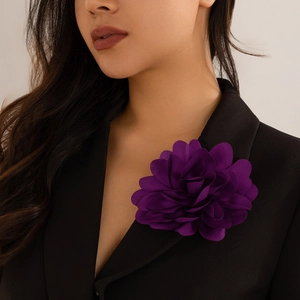 Detailed view of large dark purple fabric flower brooch on black blazer lapel