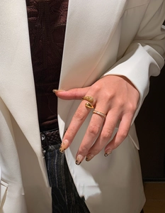 Close-up of gold-plated stacked rings set with sparkling stones on a model's hand