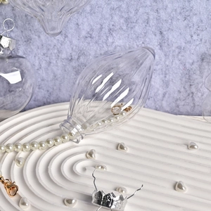 Pallina di Natale a goccia trasparente con perle su un vassoio bianco a onde