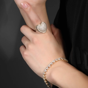 Macro shot of hip-hop gold heart ring and bracelet with paved cubic zirconia stones