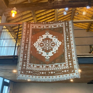 Detail of bohemian woven camping blanket with tribal patterns and decorative fringe
