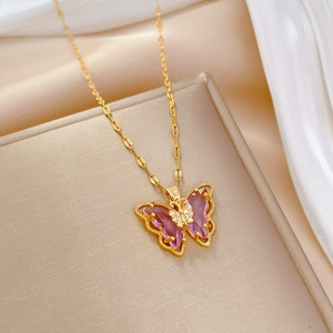 Elegant gold hollow butterfly necklace with pink crystals on a champagne jewelry box