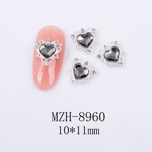 Macro detail of black heart nail charms with silver alloy frames and rhinestones