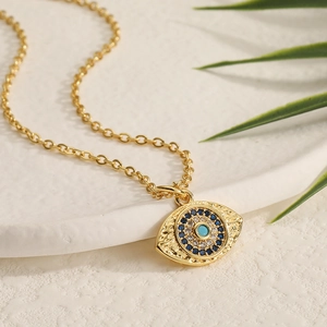 Macro detail of gold evil eye pendant featuring turquoise stone and micro-inlaid zircons