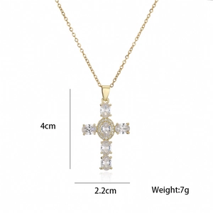 Macro shot of gold cross pendant with oval zirconia stones and size measurements 4cm by 2.2cm