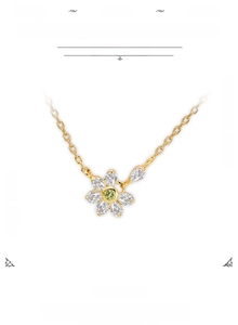 Close-up of 14K gold plated silver flower pendant with green peridot and white topaz stones