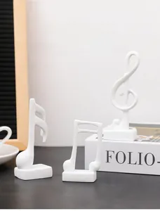 Minimalist white resin music note figurines displayed on books for home office decor