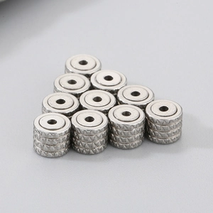 Macro detail of silver stainless steel gear earrings stoppers with diamond pattern texture