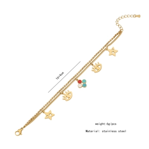 Détail du bracelet double couche en acier doré avec breloques étoile et œil bleu