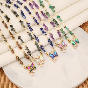 Detail of colorful natural crushed stone necklaces with sparkling zircon butterfly pendants