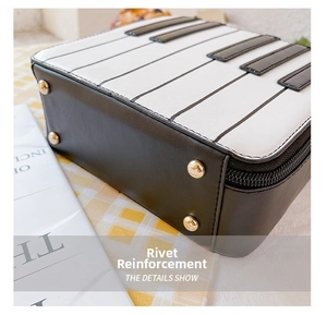 Detail view of reinforced bottom with gold-tone studs on a piano-style bow handbag