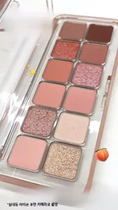 Macro shot of a 12-color eyeshadow palette with warm pink tones and assorted textures